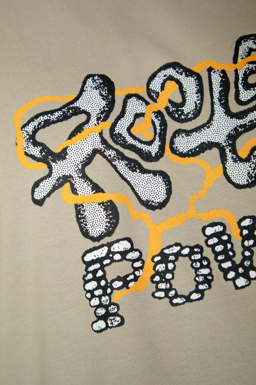 Close up detail of the grazzy Rooted Power artwork printed on the Stone colorway t-shirt.