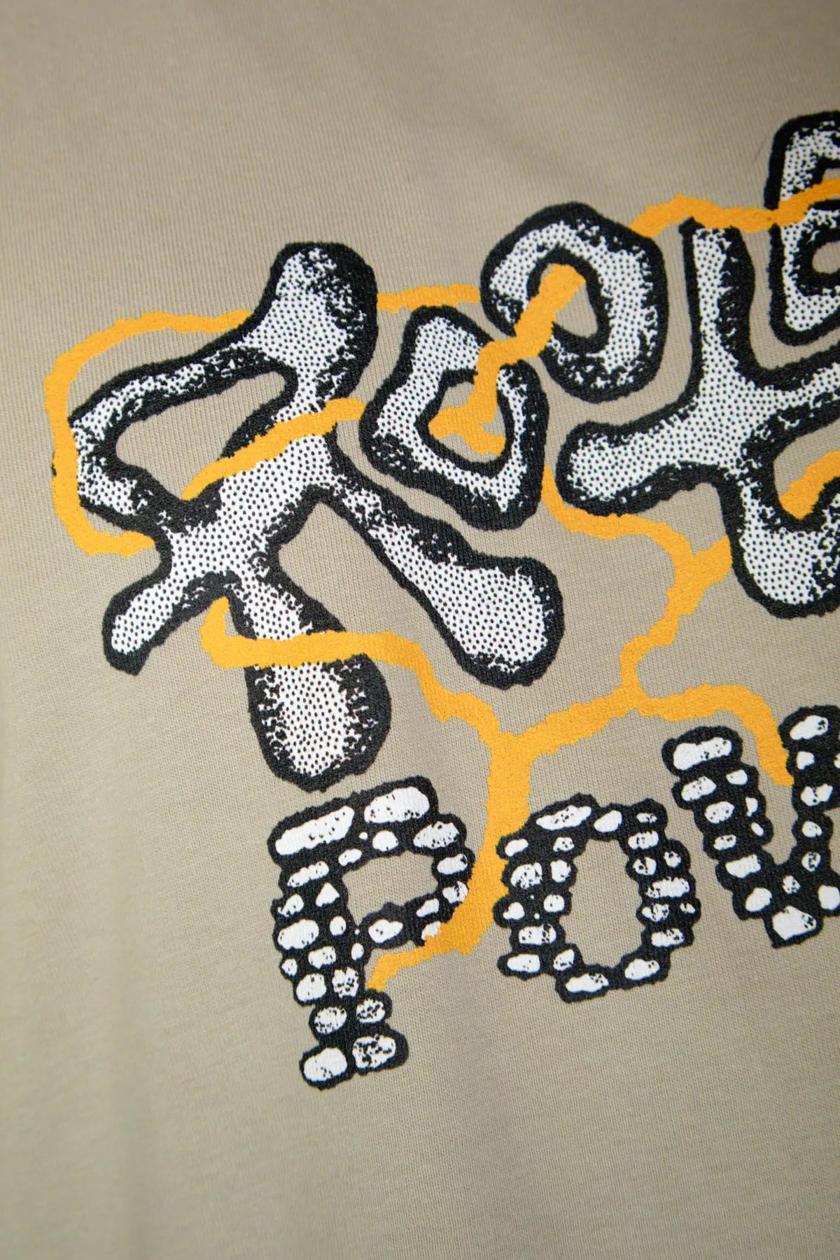 Close up detail of the grazzy Rooted Power artwork printed on the Stone colorway t-shirt.